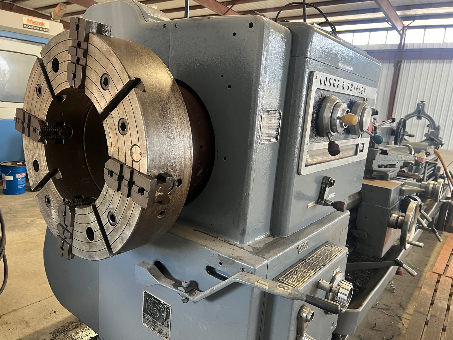 An industrial-sized Lodge and Shipley Lathe, a heavy-duty machinery with metallic components, gears, and control panels, ready for manufacturing processes.