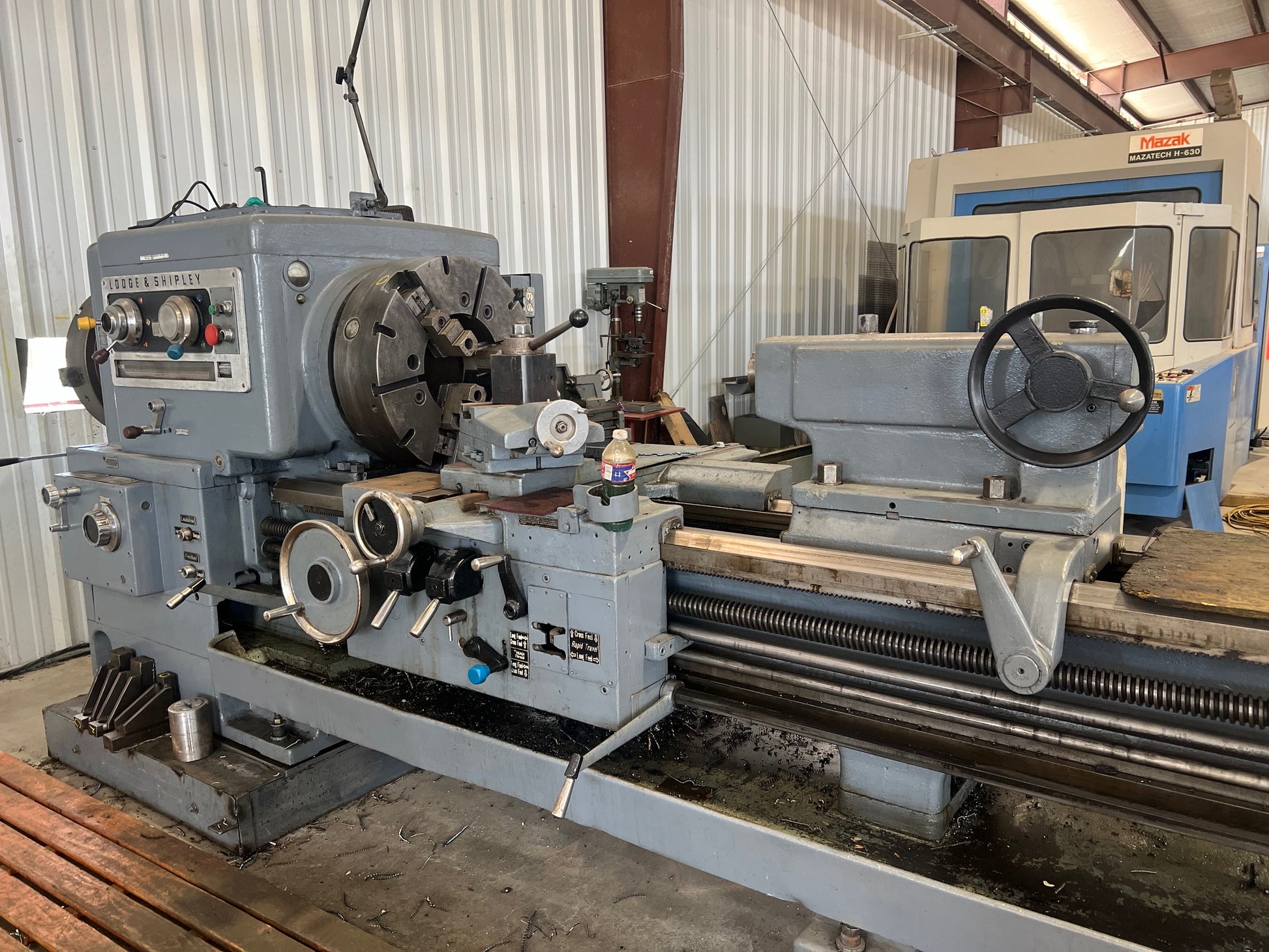 An industrial-sized Lodge and Shipley Lathe, a heavy-duty machinery with metallic components, gears, and control panels, ready for manufacturing processes.