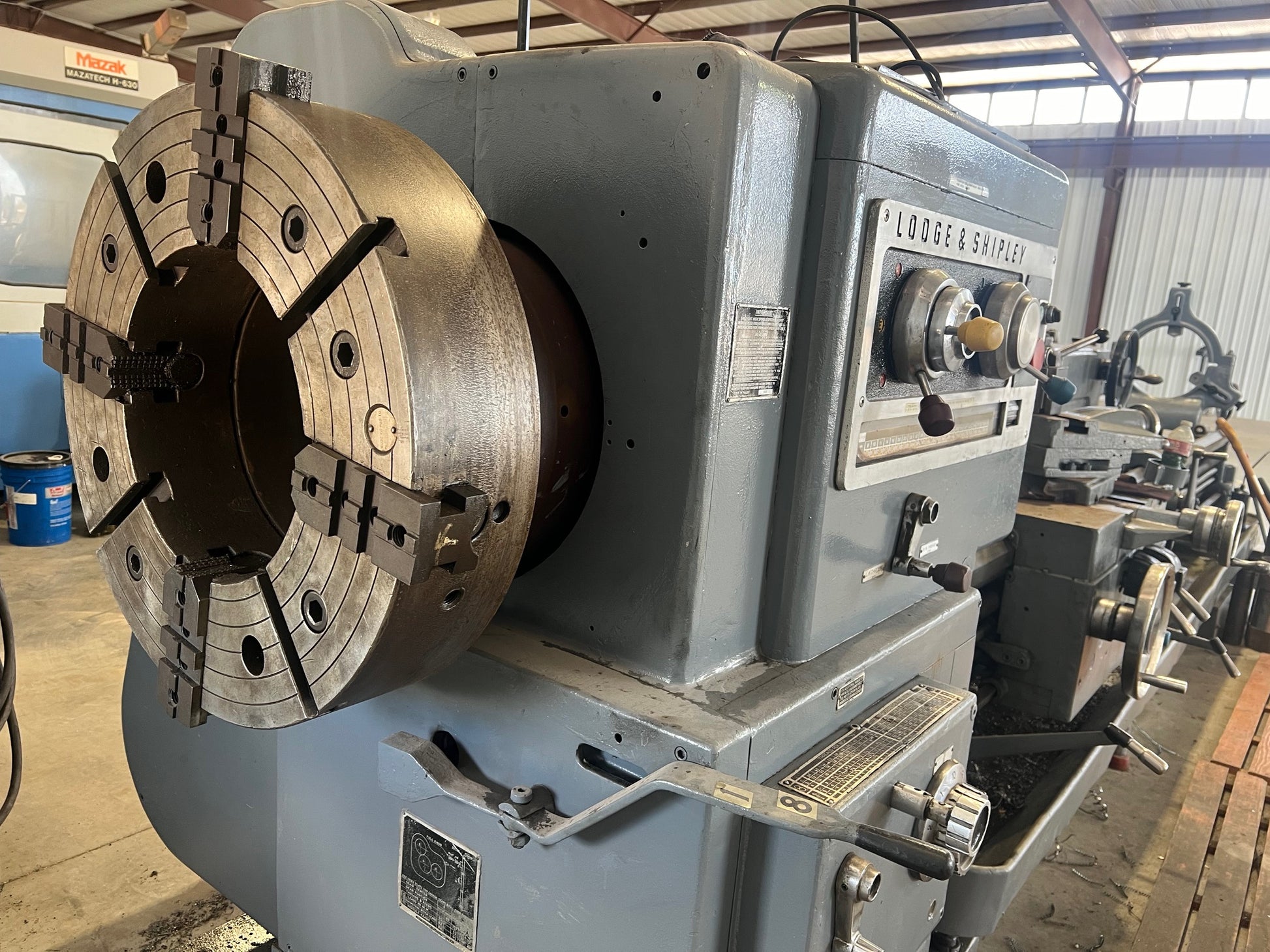 An industrial-sized Lodge and Shipley Lathe, a heavy-duty machinery with metallic components, gears, and control panels, ready for manufacturing processes.